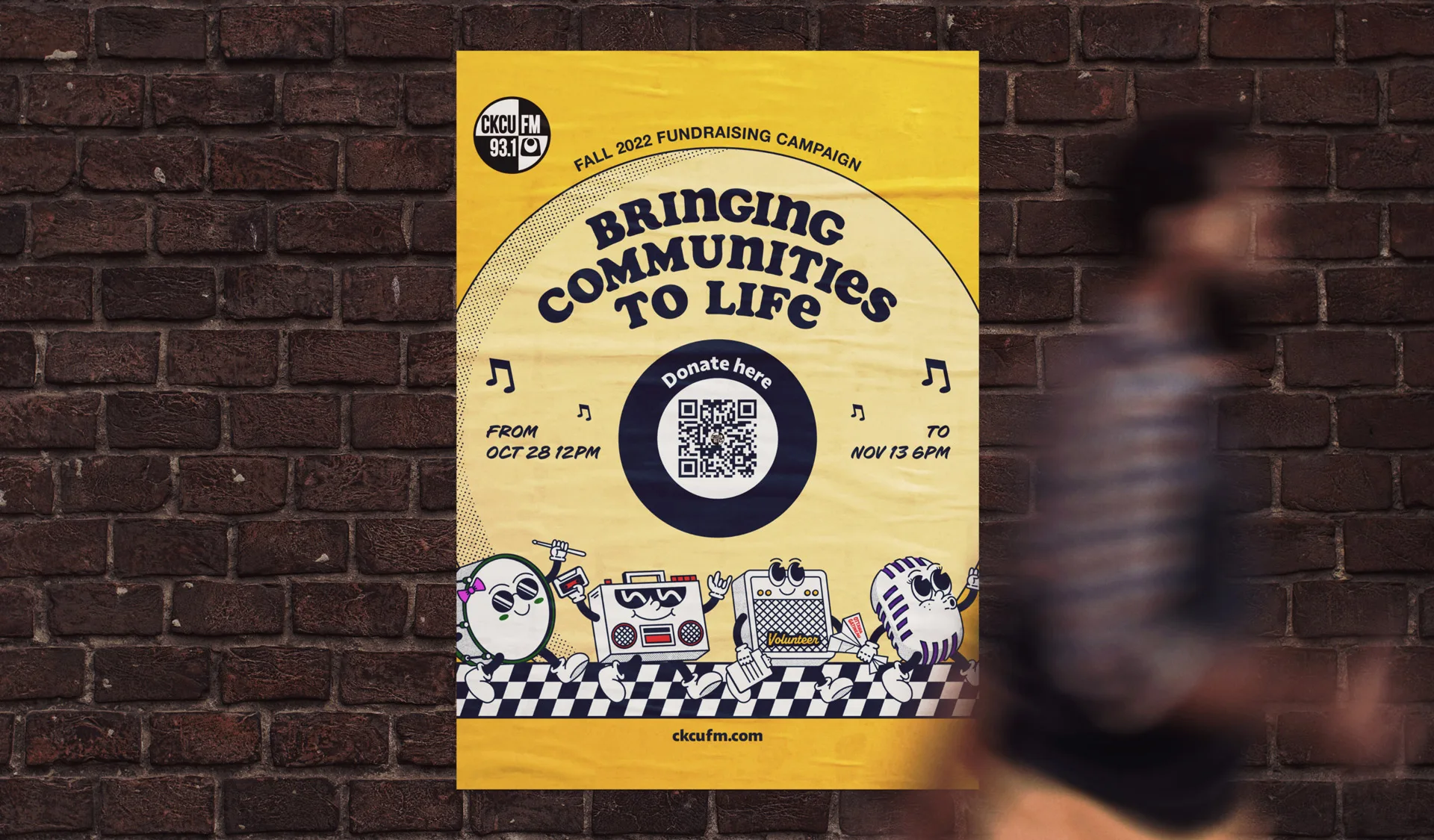 A yellow poster on a brick wall reads Bringing Communities to Life. It advertises a fundraising campaign with a QR code, dates, and cartoon characters with musical instruments. A blurred person walks by.