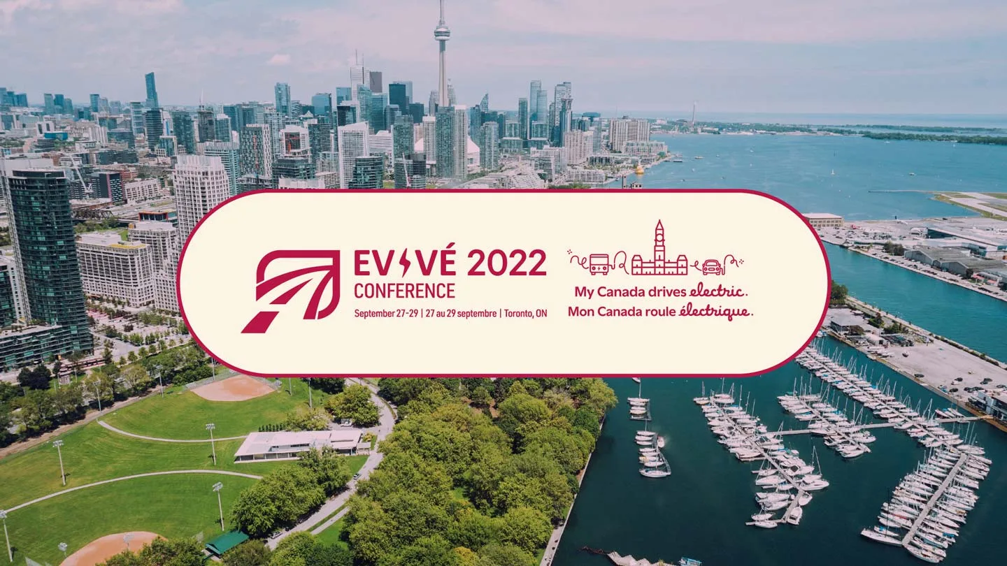 Aerial view of downtown Toronto with an EV conference banner overlay reading EV/VÉ 2022 Conference, September 27-29, Toronto, ON. My Canada drives electric. Mon Canada roule électrique.