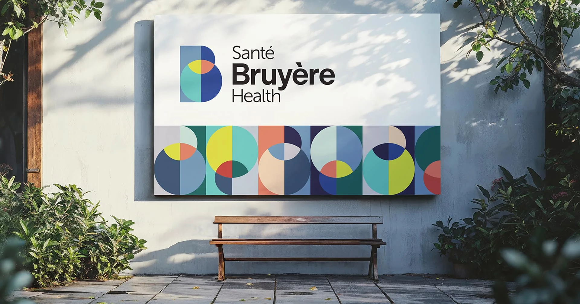 A large outdoor sign reads Santé Bruyère Health with colorful geometric shapes beneath the text. The sign is mounted on a wall above a wooden bench, surrounded by greenery and dappled sunlight.