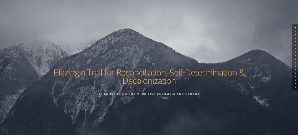 Snow-covered mountains under a cloudy sky with the text: “Blazing a Trail for Reconciliation, Self-Determination & Decolonization. Tsilhqot’in Nation v. British Columbia and Canada.”.