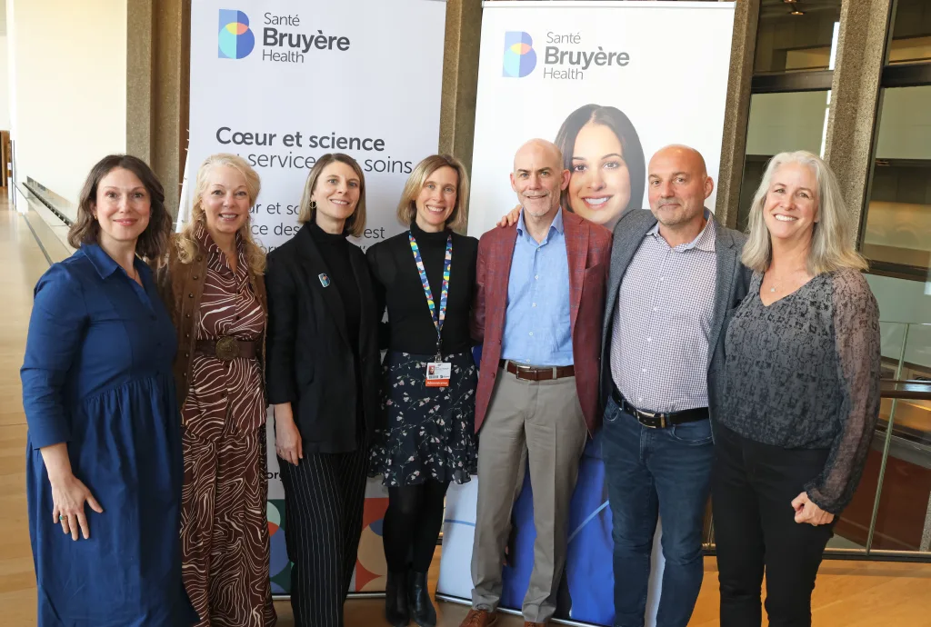 Spruce Creative team members and Bruyère Health staff posed in front of pull up banners